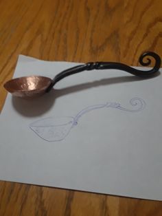 a spoon sitting on top of a piece of paper