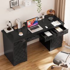 a black desk with a laptop and other items on it in front of a window