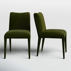 two green chairs sitting next to each other on a white surface with one chair facing the other