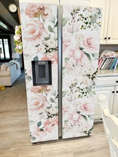 the refrigerator is decorated with pink flowers and green leaves