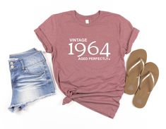 a t - shirt that says vintage, aged perfectly next to two pairs of shorts