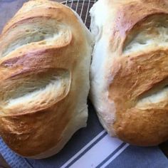 two loaves of bread sitting on top of a blue and white towel next to each other