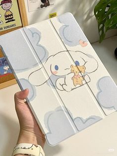 a person holding up an ipad case with cartoon drawings on the front and back cover