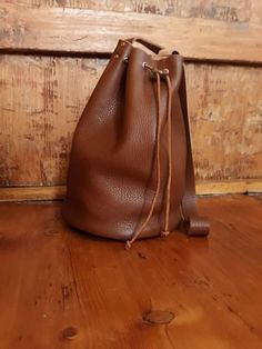 Bucket bag Leather bucket bag Hobo bag Crossbody leather bag, Hobo shoulder bag, Soft leather bucket bag, Drawstring leather purse, Woman purse,  Brown, elegant and soft leather bucket bag, large enough to carry around all the things you might need around during your day. Carefully handcrafted into the perfectvsize to get all your stuff around just nice. Safely closing with a leather string. You can either wear it as a cross body or shoulder bag.  This bag is exclusively handcrafted. The leather is manually and precisely cut having every hole individually punched. Afterwards, with close attention to details, the bag is assembled and sewed by hand. *note that I do not add any fabric linings to my bags - the inside is pure leather. Height: 30 cm / 10.6 inch Diameter: 21 cm/ 8.26 inch   Non-A Leather Bucket Satchel For On-the-go, Brown Bucket Bag For On-the-go, Brown Bucket Backpack For On-the-go, Everyday Leather-lined Crossbody Bucket Bag, Everyday Leather Handle Pouch Bucket Bag, Leather Hobo Bag With Mobile Phone Pouch, Everyday Leather Bucket Bag, Everyday Bucket Bag With Leather Handles, Everyday Pouch Bucket Bag With Leather Handles