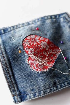 a piece of fabric with some pins sticking out of it in the back pocket of a pair of jeans