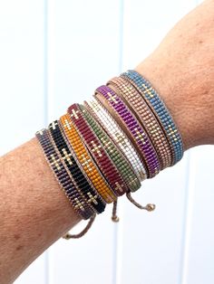 a woman's arm with several bracelets on it