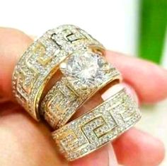 two gold wedding rings with diamonds on each one and an engagement ring in the other