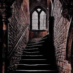 an old staircase leading up to a window in a building with stone walls and arched windows