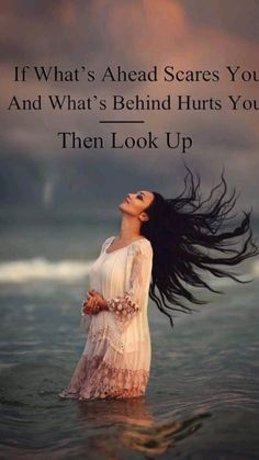 a woman standing in the water with her hair blowing in the wind and texting that reads, if what's ahead scares you and what's behind hurts hurts you then look up