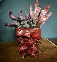 a skull vase with flowers in it on a table