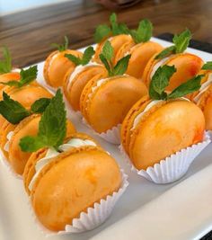 small desserts are arranged on a white plate with mint garnishes in them