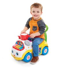 a young boy sitting on top of a toy car