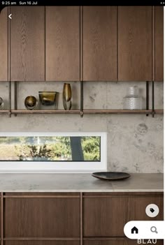 a kitchen with wooden cabinets and white counter tops, along with bowls on the shelf