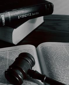 a judge's gavel sitting on top of an open book next to a law book