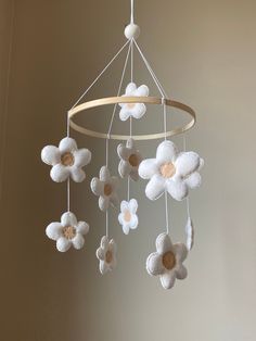 a white flower mobile hanging from a ceiling