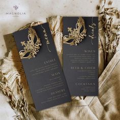 two black and gold wedding programs on top of some dried flowers, with the words venice written in gold