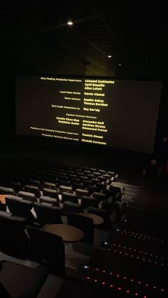 an empty auditorium with rows of seats and projection screen in the background at night time