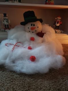 a snowman sitting in the middle of a pile of cotton