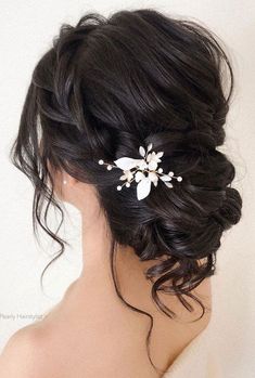 a woman wearing a hair comb with flowers on it's back and her hair in a bun