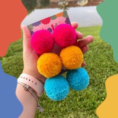 a person holding three pom poms in their hand