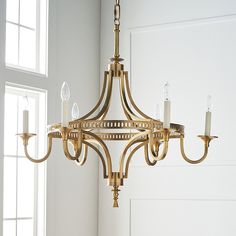 a chandelier hanging from the ceiling in a room with white walls and windows