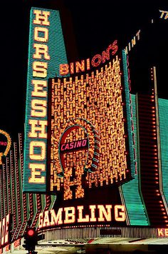 the neon sign for casino and gambling in las vegas, nv is lit up at night