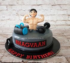 a birthday cake for a man with a bodybuilding figure on top and the words happy birthday written in red