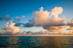 the sky is filled with clouds over the ocean