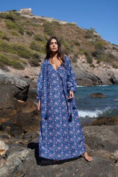 The Bella kaftan is made of light cotton silk voile and printed with vibrant florals. It has a lightweight, airy silhouette with long sleeves, button closure, and a tassel detail. This bohemian kaftan is the epitome of boho-chic style and is as elegant as it is comfortable. Bohemian Long-sleeved Kaftan With Boho Print, Long Sleeve Boho Dress For Beach, Long Sleeve Boho Dress With Floral Print, Hippie Long Sleeve Kaftan For Beach Cover-up, Hippie Long Sleeve Kaftan For Beach, Bohemian Long Sleeve Boho Dress With Floral Print, Flowy Long Sleeve Boho Print Kaftan, Long Sleeve Bohemian Boho Dress With Floral Print, Long Sleeve Bohemian Dress With Floral Print