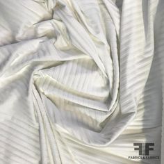 an image of white fabric that looks like it has been made into a bed sheet