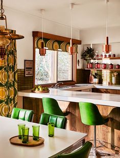 the kitchen is clean and ready to be used for dinner or lunch time, as well as green chairs