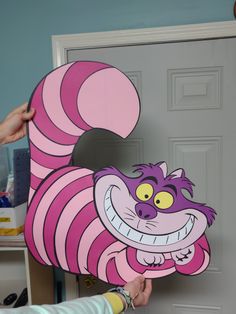 a person holding up a cut out of a cartoon character