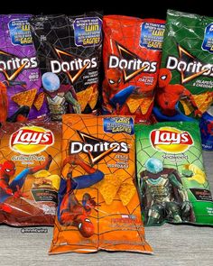 five bags of chips are sitting next to each other on a table with spider - man