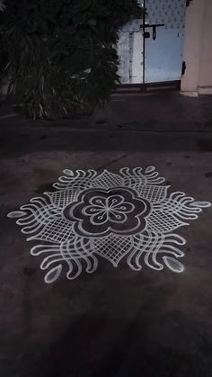 an intricate design on the ground in front of a building with a door and window