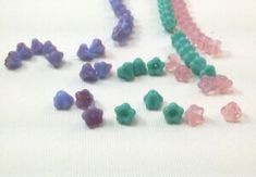 several different colored beads on a white surface