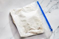 a bag of flour sitting on top of a counter next to a blue plastic pen