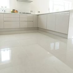 an empty kitchen with white cabinets and counter tops