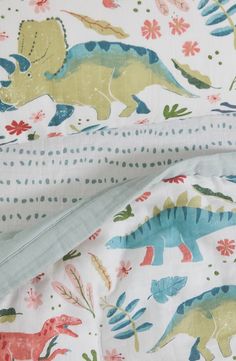 two sheets with dinosaurs on them are laying next to each other in the same pattern