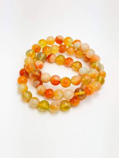 Citrus Beaded Stack Bracelets Handmade Orange Spiritual Bracelets, Orange Spiritual Beaded Bracelets, Adjustable Orange Beaded Spiritual Bracelet, Adjustable Orange Spiritual Beaded Bracelet, Spiritual Orange Adjustable Beaded Bracelets, Handmade Orange Stretch Bracelet With Round Beads, Handmade Orange Bead Stretch Bracelet, Orange Stretch Bracelet With 8mm Beads, Orange Hand-strung Jewelry With Round Beads