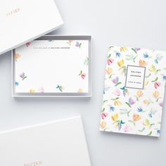 three personal notepads in a box on a white surface with colorful flowers printed on them