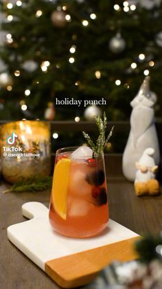 a holiday punch on a cutting board next to a christmas tree