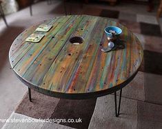 a wooden table with paint on it in a living room next to a couch and coffee table