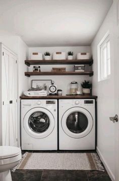 a washer and dryer in a small room with open shelving on the wall