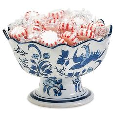 a blue and white bowl filled with red and white striped candies on a white background