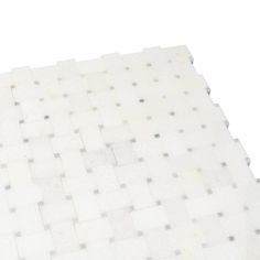 a white tile floor with squares and dots on it