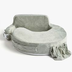 a grey dog bed with ruffles on the bottom and side, in front of a white background