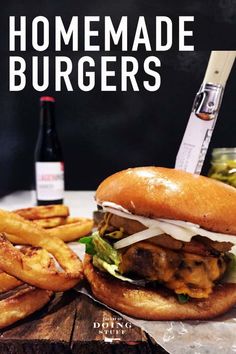 a sandwich and french fries on a table with a bottle of beer in the background