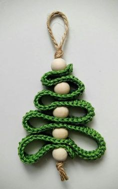 a green and white christmas tree ornament hanging from a string on a wall