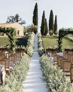 an outdoor ceremony with rows of chairs lined up along the aisle and trees in the background