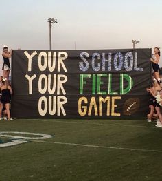 some cheerleaders are standing on the sidelines with a sign that says your school is field our game